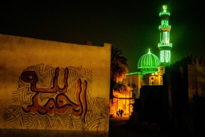 The mosque lights up the street at night